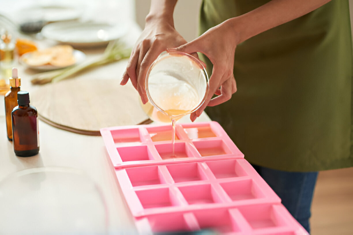 pouring melted soap material into a mold